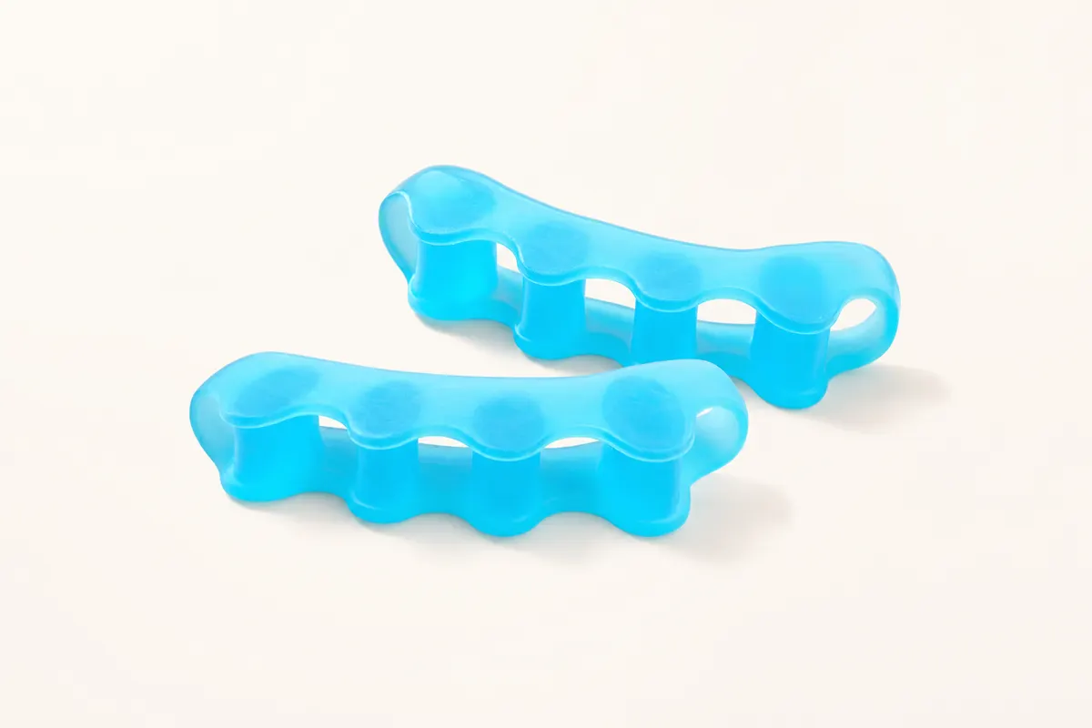 Pair of blue ToeRoom gel toe spacers on a warm porcelain background